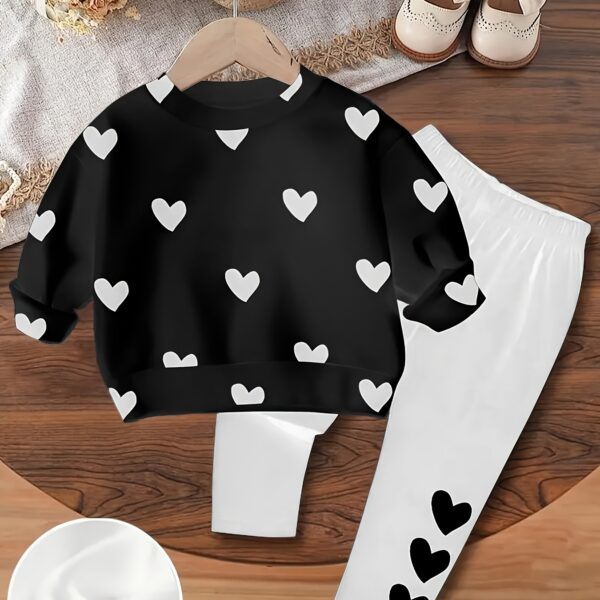 Adorable girls' playful set featuring a sweet heart print, perfect for fall and winter. The outfit includes [mention pieces included, e.g., a sweater and leggings] in soft, comfortable fabrics.