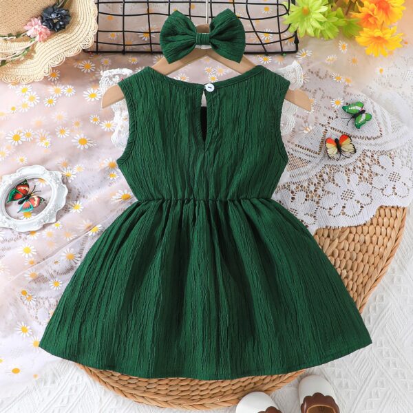 Toddler girl wearing a charming emerald green summer dress, ideal for playing outdoors.
