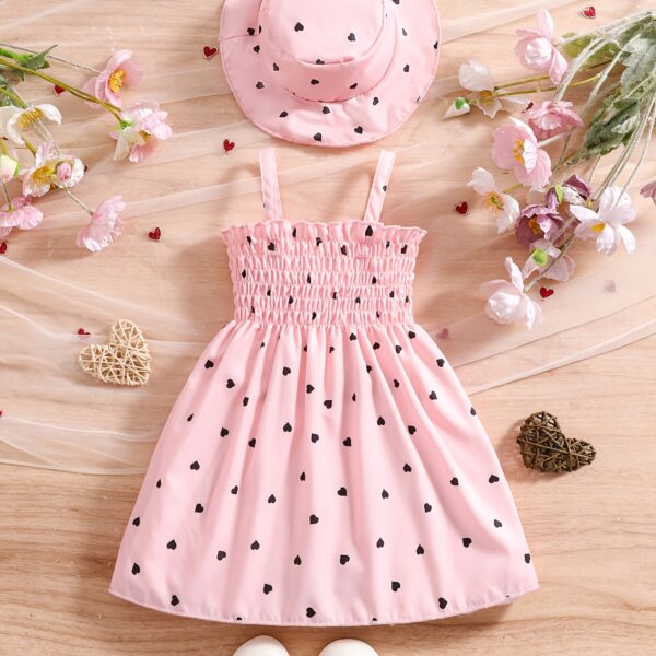 Girl wearing adorable Summer Bloom heart print dress and matching hat set.