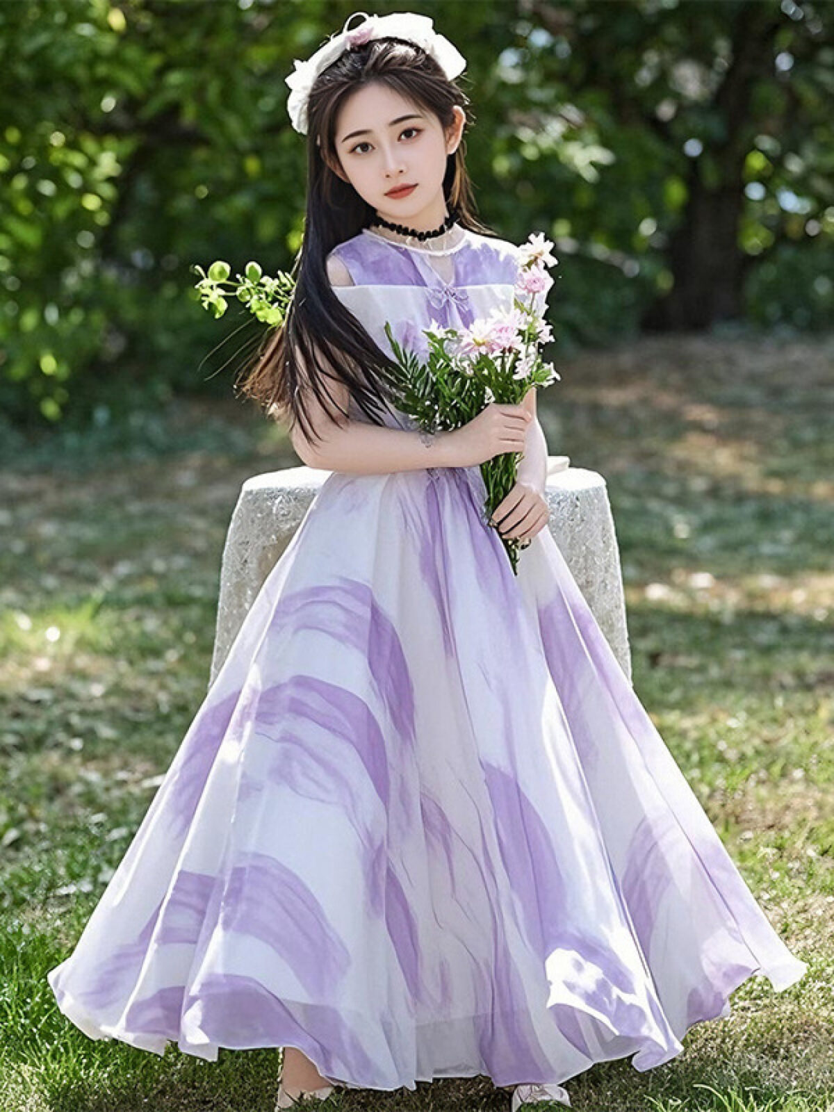 Adorable girl twirling in a flowy elegant chiffon dress perfect for summer The dress is in a beautiful summer garden setting