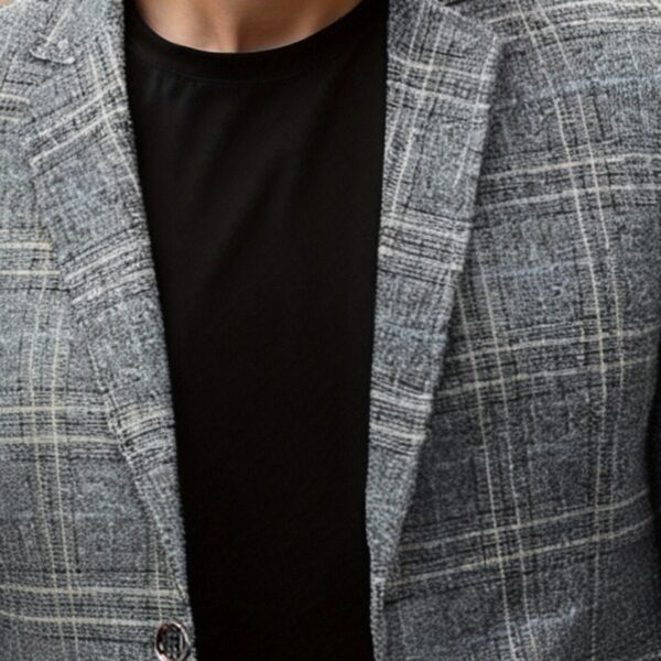 The Newness Metropolitan Checkered Blazer in spring style. A close-up showcases the premium fabric and refined, modern look.