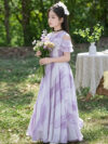 Adorable girl twirling in a flowy elegant chiffon dress perfect for summer The dress is in a beautiful summer garden setting