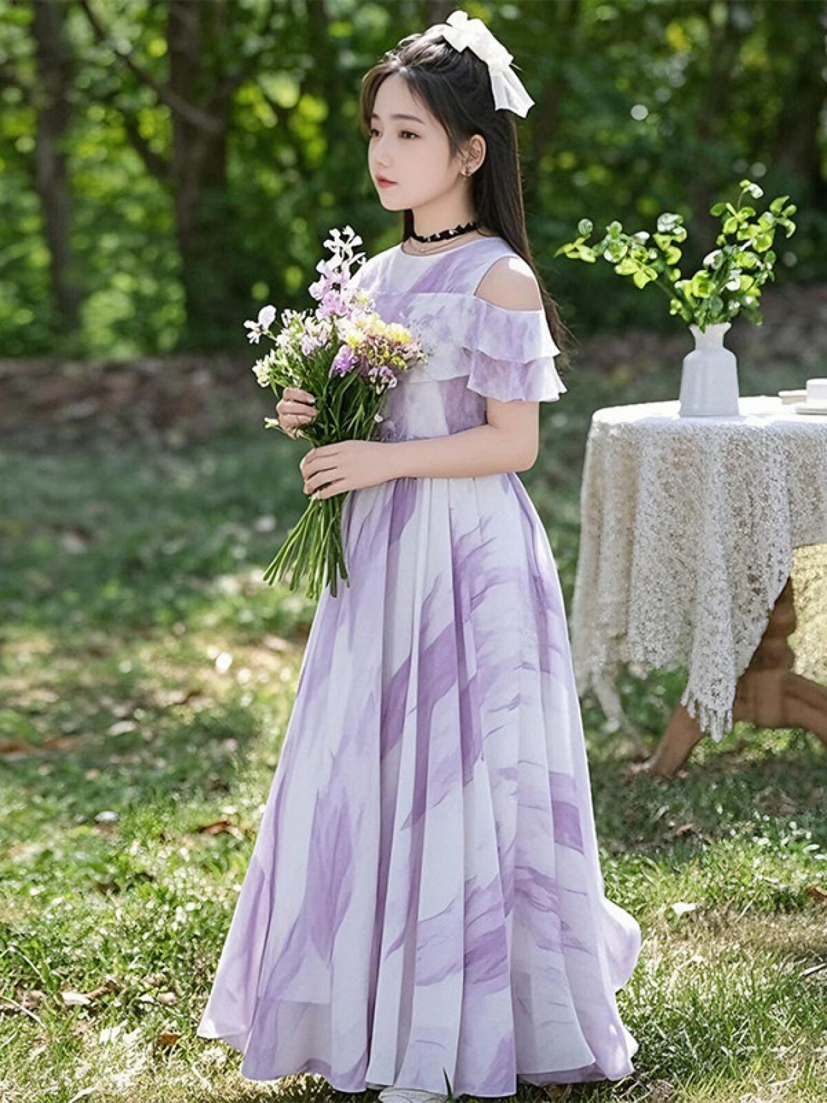 Adorable girl twirling in a flowy elegant chiffon dress perfect for summer The dress is in a beautiful summer garden setting