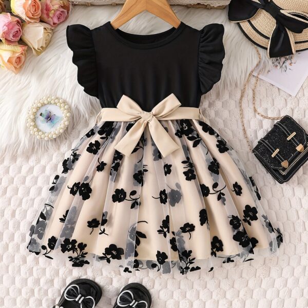 Adorable little girl twirling in a beautiful summer floral mesh dress from Newness. The dress is lightweight and perfect for warm weather.