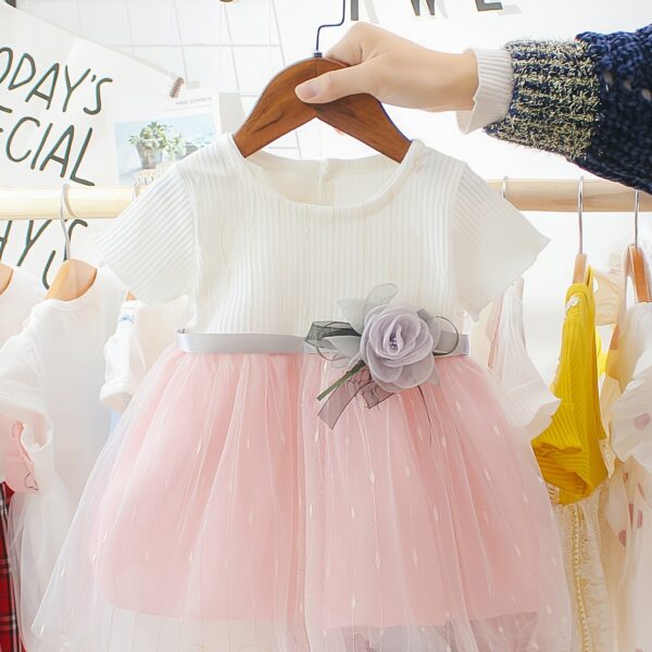 Adorable little girl twirling in a pink Summer Bloom Rose Princess Dress from Newness, showcasing its comfortable and stylish design.