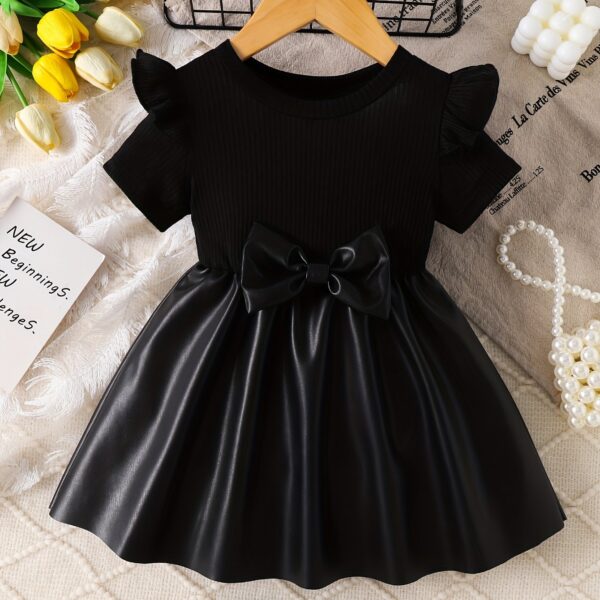 Adorable baby girl wearing a charming Little Darling Baby Bow Dress, perfect for parties or playdates. The dress features a beautiful bow detail.