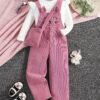 Adorable little girl wearing a playful cat embroidered jumpsuit perfect for spring or autumn The jumpsuit is comfortable and stylish